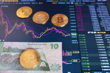 Kağıt fatura Kırgız 10 kg, arka plan bulanık. Birim bitcoin borsasında elektronik zamanlama, esnaf, monitörde altın bitcoin yalan.