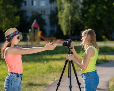 İki kız kız. Doğa yazın. Video kamera için yazar. Kayıt vlog ve blog. Internet için kayıt video ders. Kullanma fotoğraf makinesi tripod ile.