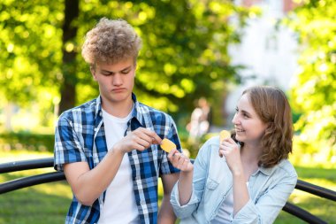 Açık havada bir parkta genç öğrenciler yaz aylarında. Şehirde bir bankta oturuyorlar. Kız ve mutlu gülümseyerek adama yiyecek verir. Adam utanıyor. Güvensizlik kavramı. Duygu iyilik.