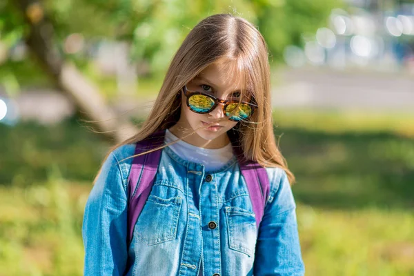 Tenåringsjente. Nært portrett, bak ryggsekk, solbriller. Følg nøye med. . – stockfoto
