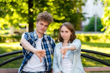 Genç bir kız öğrencilerle adam. Doğa parkında yazın. Aşağı parmağını jestleri. Disko. Güvensizlik kavramı. Duygu iyi çalışmıyor. Kötü sonuç.