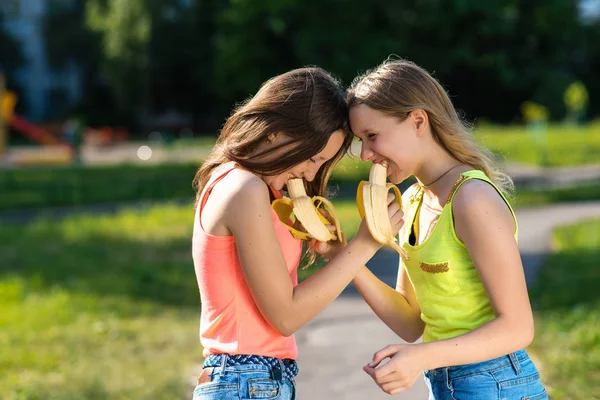 Девочки школьницы. Съешь бананы на перерыв. Лето на природе. Концепция здорового завтрака. Эмоции - это счастье получать удовольствие от веселых шуток и улыбок . — стоковое фото