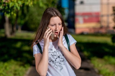 Kız kız öğrenci genç, yaz açık. Telefonda konuşurken bir smartphone holding eller. Kavramı, gizem, şok. Duygu sürpriz, zevk, korku.