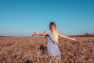Alan genç kız. Yaz parlak güneşli bir günde. Silah uzanmış destek. Elbise ve uzun saç, tabaklanmış deri garanti et. Mutluluk, eğlence, doğa kavramı. Duygu zevk.