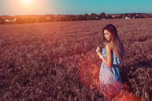 Beautiful young summer girl in field. Happy smiling dreams, sensually and gently fantasizes. Free Space for text. Walking in the field. Tanned skin light summer dress. — Stock Photo, Image