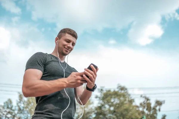 Der Athlet Hält Ein Smartphone Der Hand Glücklich Lächelnd Kommuniziert — Stockfoto