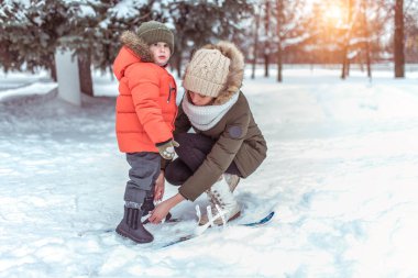 Genç bir anne onu genç oğlu, bir çocuk 3-5 yaşında çocuk Kayak elbiseleri. Kışın park açık rekreasyon.