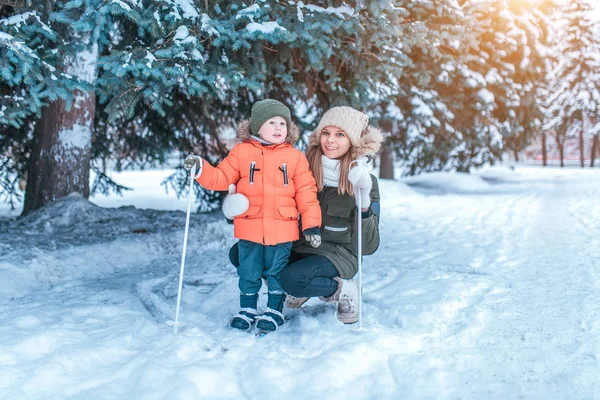 Mutter und Sohn im Winterpark, Skifahren auf Kindern. glücklich lächelnd, entspannt außerhalb der Stadt. — Stockfoto