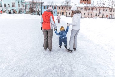 İki Genç Anne paten küçük çocuk çocuk 3-4 yaşında öğrenin. Kış, buz şehir içinde buz pateni.