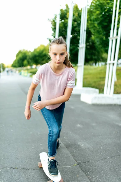 Dospívající dívky 10-12 let, v létě ve městě, jízda na skateboardu. Pihy na obličeji. — Stock fotografie