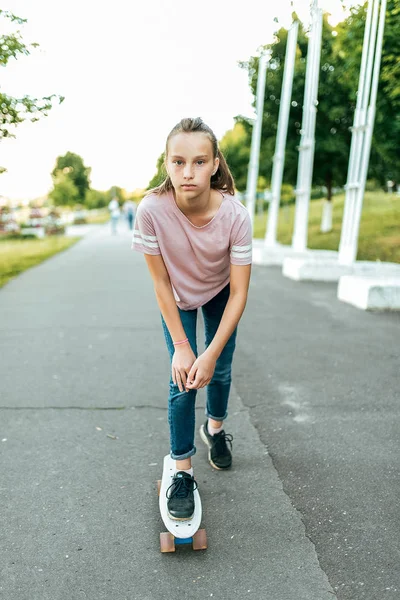 Gadis remaja di musim panas di kota, naik skateboard. Bintik-bintik di wajah . — Stok Foto