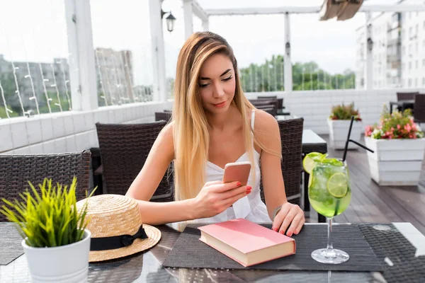 Kişi, yaşam tarzı, teknoloji ve modern elektronik becerikli alet. Çevrimiçi iletişim genel cep telefonunda mesajlaşma programları ile manifatura arkadaş güzel kadının kafe, rahatlatıcı sarışın saç modeli ile