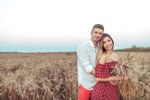 Hermosa pareja joven, hombre mujer abrazo campo de trigo de verano. Manos espigas de trigo. Concepto de amor que cuida, abrazando la felicidad y el apoyo familiar. Espacio libre para texto. Emoción alimentos saludables y productos ecológicos . — Foto de Stock