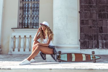 Mutlu gülümseyerek telefon ederek yönetim kurulu longboard kaymak ile güzel kız yaz. Online başvuru video aramak için sosyal ağlar. Duygular sevinç ve eğlence. Metin için boş alan.