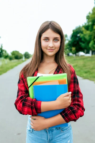 女学生少女 10-15, 夏季城市放学后的课程。手里拿着文件和笔记本笔记。快乐的微笑在城市公园。学院教学理念是积极的态度. — 图库照片