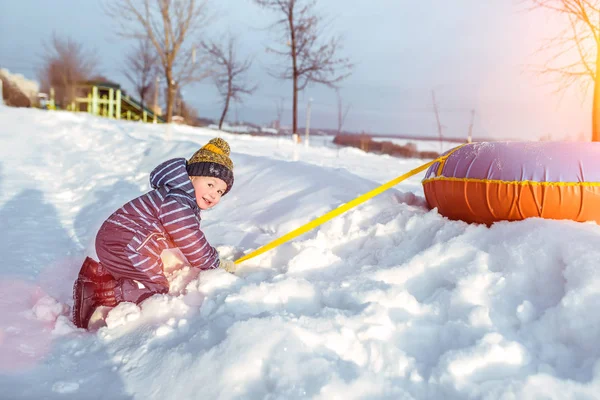 小男孩 3-5岁, 在冬天的自然, 快乐的微笑, 玩雪和雪漂流与油管。欢乐和乐趣的情绪, 在寒冷的冬日户外娱乐. — 图库照片