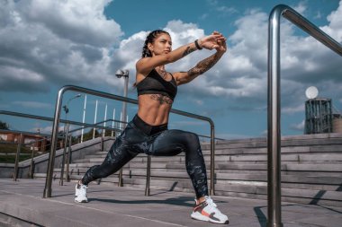 Dövmeler, spor giyim, tozluk ve üst güzel genç kadın. Şehirde yaz, bacaklar, fitness, egzersiz koşu önce şehrin önce ısınma kasları eğitim.