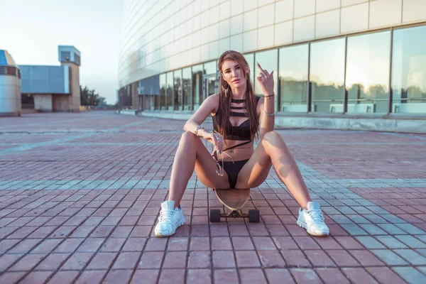 Beautiful girl, summer city skateboard. Black swimsuit, gesture of hand shows middle finger. Symbol go walk, piss off. Confidence courage, strong character, tough resistance, Fu k off, Free space. — Stock Photo, Image