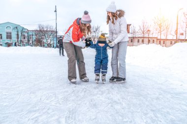 Çocuk patenleri küçük bir çocuğa eğitim, ebeveyn eller, kentin sokakta kışın pistinde paten ilk ders childs tutun. Kızlar kadınlar kız.