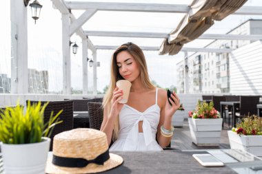 Kafede kız. Burnunu çekmek ve kahve sahiptir, çayın kokusu kokusu alır zevk inhales. Rahatlatıcı yaz Restoran verandada. İş kadını zor bir iş günü sonra öğle yemeği.