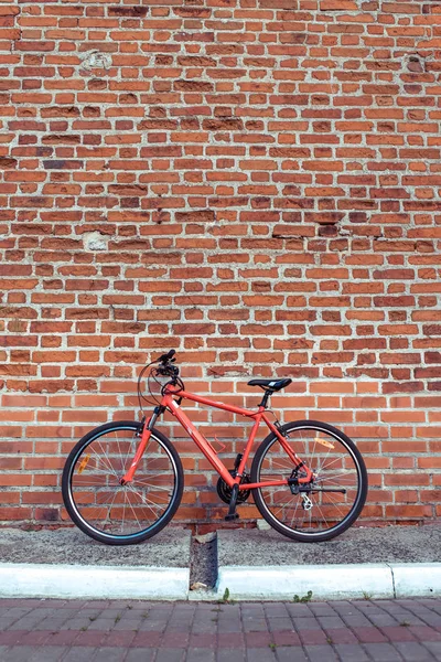 도시에서 여름에 빨간 자전거 서 오래 된 벽돌 벽에 주차 된 있다. 텍스트에 대 한 여유 공간입니다. 주차장, 걷고, 수리, 자전거 바퀴와 바퀴와 프레임의 개념. — 스톡 사진