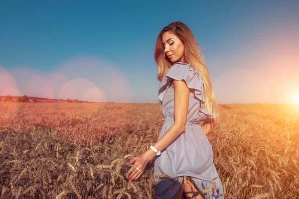 Flickan i en klänning, promenader i sommar i vete fältet. Lycklig vila i naturen. Ljus solig dag, med långt hår, livsstil en kvinna. — Stockfoto