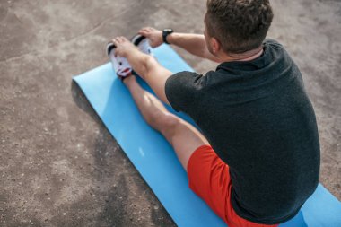 Erkek atlet, yaz aylarında şehirde minyon. Bir egzersiz, jimnastik, fitness yok. Aktif yaşam tarzı, yoga eğitimi. Doğada fitness. Gündelik giyim. Geri görünüm.