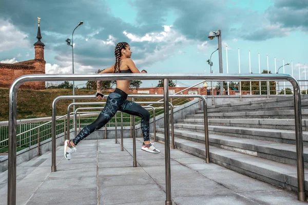Girl on morning run summer city on background steps of clouds and metal handrails. Olahraga kebugaran, gaya hidup aktif orang muda. Motivasi adalah kekuatan, prestasi, kesuksesan. Ruang kosong . — Stok Foto