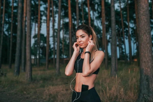 Wanita cantik taman musim panas, mendengarkan musik telepon, pagi joging berjalan malam di udara segar. Headphone pelatihan playlist, joging pagi dan malam. Gaya hidup aktif, pakaian olahraga legging atas . — Stok Foto