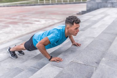 Genç adam, bir erkek atlet, yaz şehirde, göğüs ve silah, aktif yaşam tarzı, sağlık ve spor kavramı, tam uzunlukta spor, spor bilezik, kolunda egzersiz kasları dışarı sıkmak olduğunu.