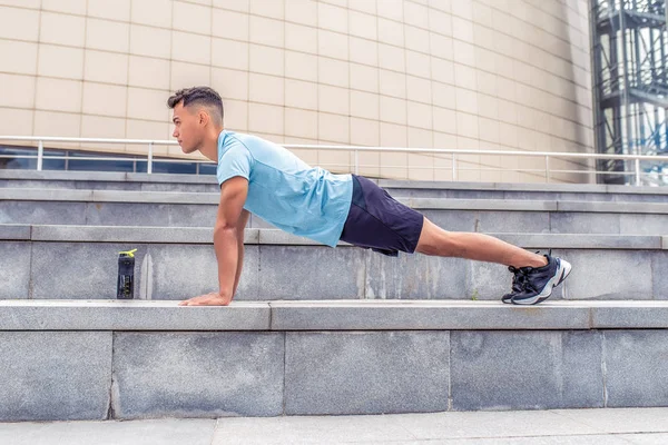 Erkek atlet, yaz aylarında şehir, göğüs ve silah, aktif yaşam tarzı, konsept sağlık spor kasları eğitim dışarı koparılmış. Bir şişe protein, Gainer, su ile shaker, spor giyim.