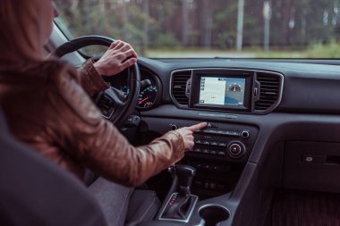 kız araba sürme, acil durdurma düğmesine basar, güvenlik açar, sinyal kapalı, yolda kaza, yolda tehlike uyarmak, karayolu üzerinde kaza. Otomatik şanzıman, dokunmatik ekran, navigasyon arka plan.