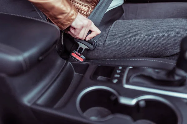 Primo piano di fissaggio della cintura di sicurezza in auto, meccanismo a scatto e a mano, sicurezza stradale, attivazione degli airbag, salvataggio di vite umane, azione di movimento interno dell'auto, mano femminile . — Foto Stock
