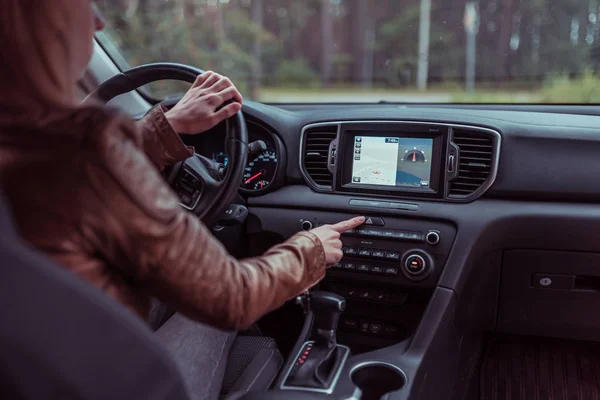 Gadis mengemudi mobil, menekan tombol berhenti darurat, menyalakan keamanan, sinyal dimatikan, kecelakaan di jalan, memperingatkan bahaya di jalan, kecelakaan di jalan raya. Gearbox otomatis, layar sentuh, latar belakang navigasi . Stok Foto