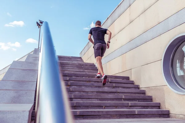 Чоловік біжить по сходах вранці, влітку в міських спортивних футболках кросівки, на задньому плані сходів поручень, вільне місце . — стокове фото