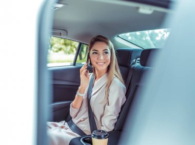 telefonda konuşan kız, yazlık şehir taksi, oturan araba, kapı açılır, mutlu gülümseyerek, arkadaşı araba toplantı, şehir taksi seyahat keyfi. Bir fincan kahve, uzun saçlı resmi takım elbise, bir iş kadını.