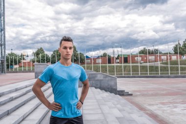 Yaz aylarında şehirde erkek atlet, kendine güvenen bir görünümle poz veriyor. Düşünce gücü kavramı, bir antrenör duyguları, şehirde fitness coo. Boş alan. Erkeklik ve yaşamda liderlik.