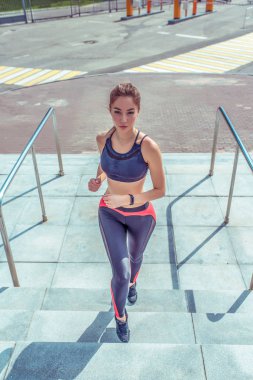 Kadın atlet sabah bir koşu üzerinde çalışır, şehirde yaz aylarında, merdivenlerde, fitness yapan güzel bir kız, gençlik yaşam tarzı, şehirde sağlıklı yaşam tarzı. Spor. Toz -luk. Sayfanın Üstü. Ayakkabı.