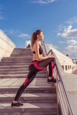 Kız eğitim başlamadan önce, merdivenlerde uzanan bacak eğitim, jimnastik fitness eğitimi öncesi kasları ısınma. Spor Giyim Tozluk Üst.