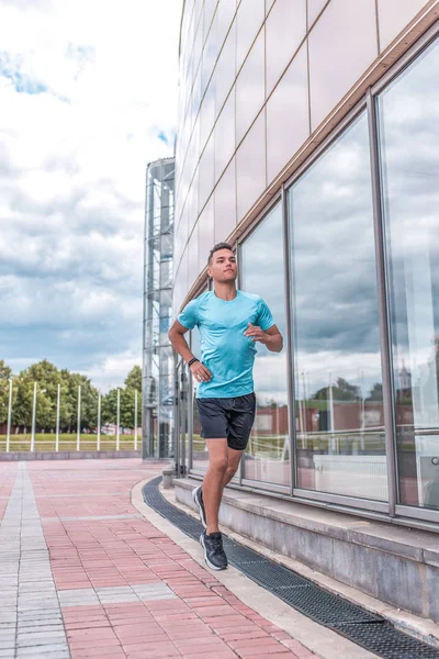 アスレチック男性アスリートは、夏には午前中にジョギング、フィットネススポーツワークアウトを行うためのモチベーション、朝のトレーニングで市内を走ります。若者のアクティブなライフスタイル、パワフルでスタイリッシュな男. — ストック写真