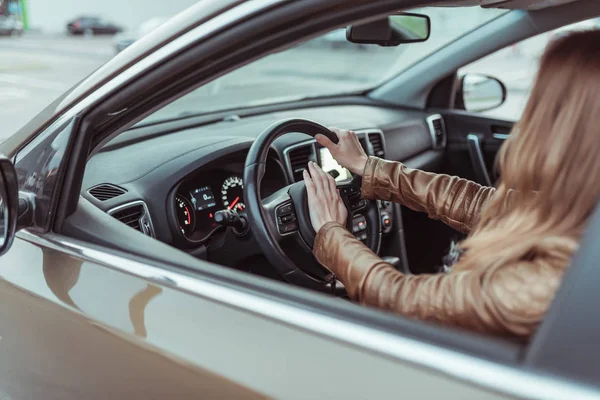 Una mujer en el coche, hace clic en el cuerno, frenado de emergencia, alarma, sonido del coche, prevención de accidentes, emergencia en la carretera, frenando el coche a una parada completa. Chica en una chaqueta en verano y otoño . — Foto de Stock