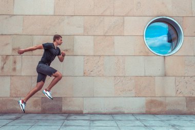 adam yaz i şehir, koşu atlama. Aktif yaşam tarzı, fitness egzersiz, hareket motivasyon, hızlı ve spor atlet adam, atlet. Motivasyon metni için boş alan. Spor Giyim T-shirt Şort Spor Ayakkabı.