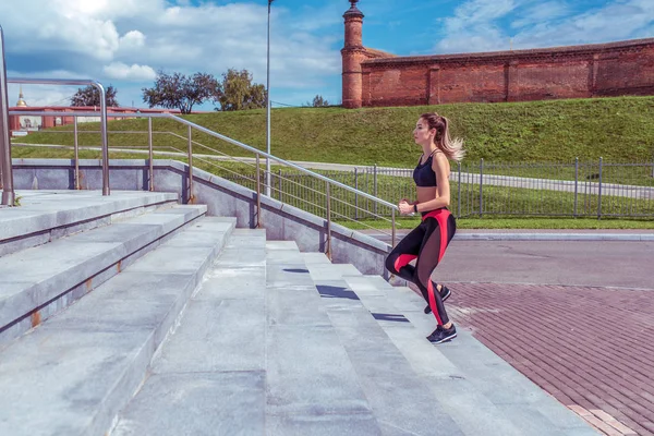 Дівчата спортсмени, бігають влітку в місті на ранковому бігу, на сходах. Вільний простір для тексту, мотивація пристосованості способу життя молодої жінки. Кроки фону зелені газони . — стокове фото
