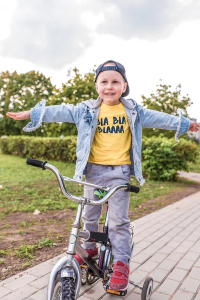Little boy, child of 3-5 years old, happy to ride bicycle, summer spring autumn day in city park, keeps his balance, rests on weekends, learns to ride bicycle training and dexterity. — Stok fotoğraf
