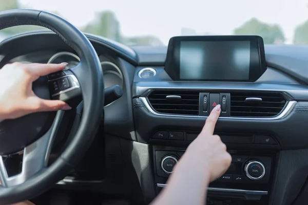 Gros plan, la main féminine appuie sur le bouton d'arrêt d'urgence, alarme accident sur la route, danger et un avertissement aux automobilistes sur l'autoroute tout en voyageant, signal d'urgence avec des dimensions panneau d'arrêt d'urgence . — Photo