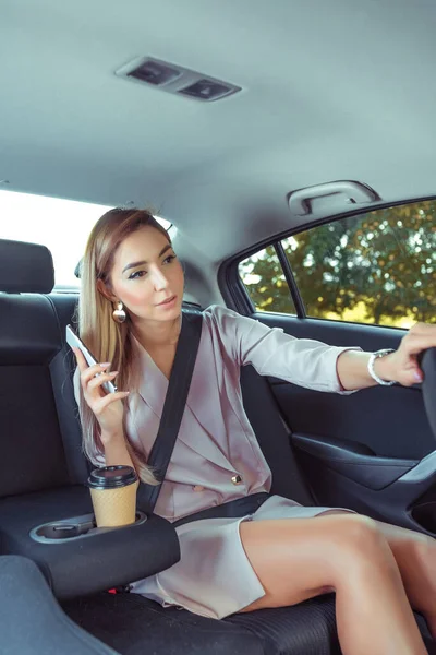 woman taxi, asks stop driver while driving, stop demand, communication driver, between passenger taxi driver. Business class, fashionable stylish business, summer spring, autumn, mobile phone, call.