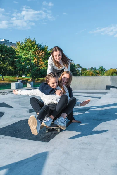 3 remaja perempuan 12-15 tahun, bermain skateboard yang menyenangkan, musim panas musim semi kota, akhir pekan setelah pelajaran. Happy smiles relax ride laugh, rejoys, after school college sweater sports field . — Stok Foto