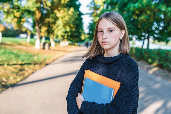 Piękna nastolatka dziewczyna 13-15 lat, lato jesień park wiosenny, posiada notebooki foldery podręczników strony. Darmowy kosmiczny tekst uczący się w szkole. Wykształcenie dzieci studiują miasto. Szczęśliwa uczennica. — Zdjęcie stockowe