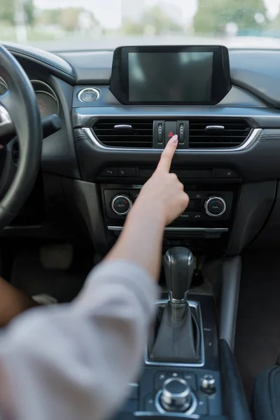 Женское колесо автомобиля нажимает кнопку аварийной остановки, активируя сигнал об аварии и дорожно-транспортном происшествии. Включение предупреждающих размеров на дороге . — стоковое фото