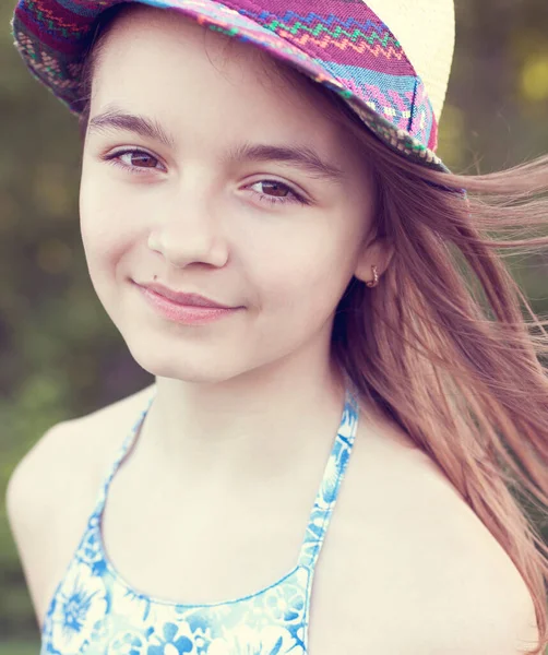 Close-up portret van een kind, mooi klein tienermeisje in een hoed, zomer buiten, emoties van geluk glimlacht en ontspanning. Lang haar ontwikkelt zich in de wind. — Stockfoto